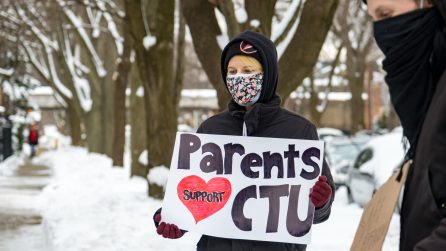 Parent in full winter garb holding sign reading "Parents support CTU" (Photo credit: Sarah-Ji of Love + Struggle)