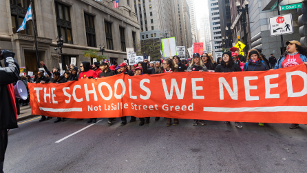 CTU members holding a banner reading "The Schools We Need, Not LaSalle Street Greed" during the 2019 Teachers Strike [Photo Credit: Sarah-Ji of Love+Struggle Photos]